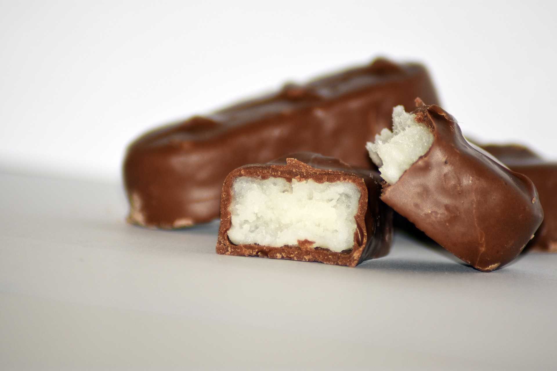 Bild: Schokoladenkurs - 3 vollwertige Bounty, zwei davon halbiert liegen auf einem Tisch nebeneinander.